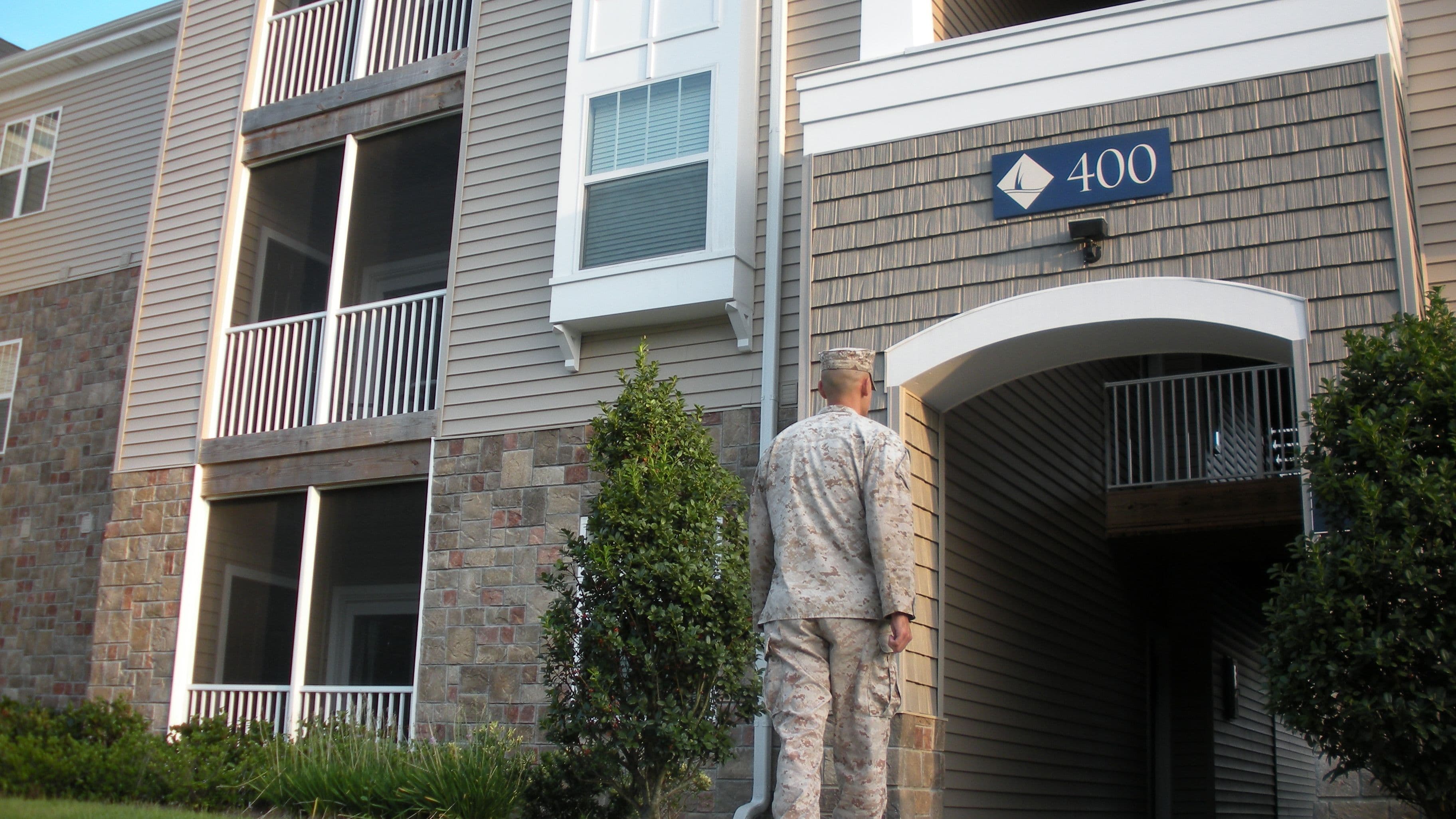 A soldier walks into the front door of military housing.